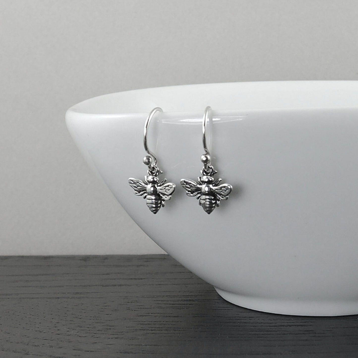 Sterling silver dainty earrings on silver hook ear wires with a charming bee design.