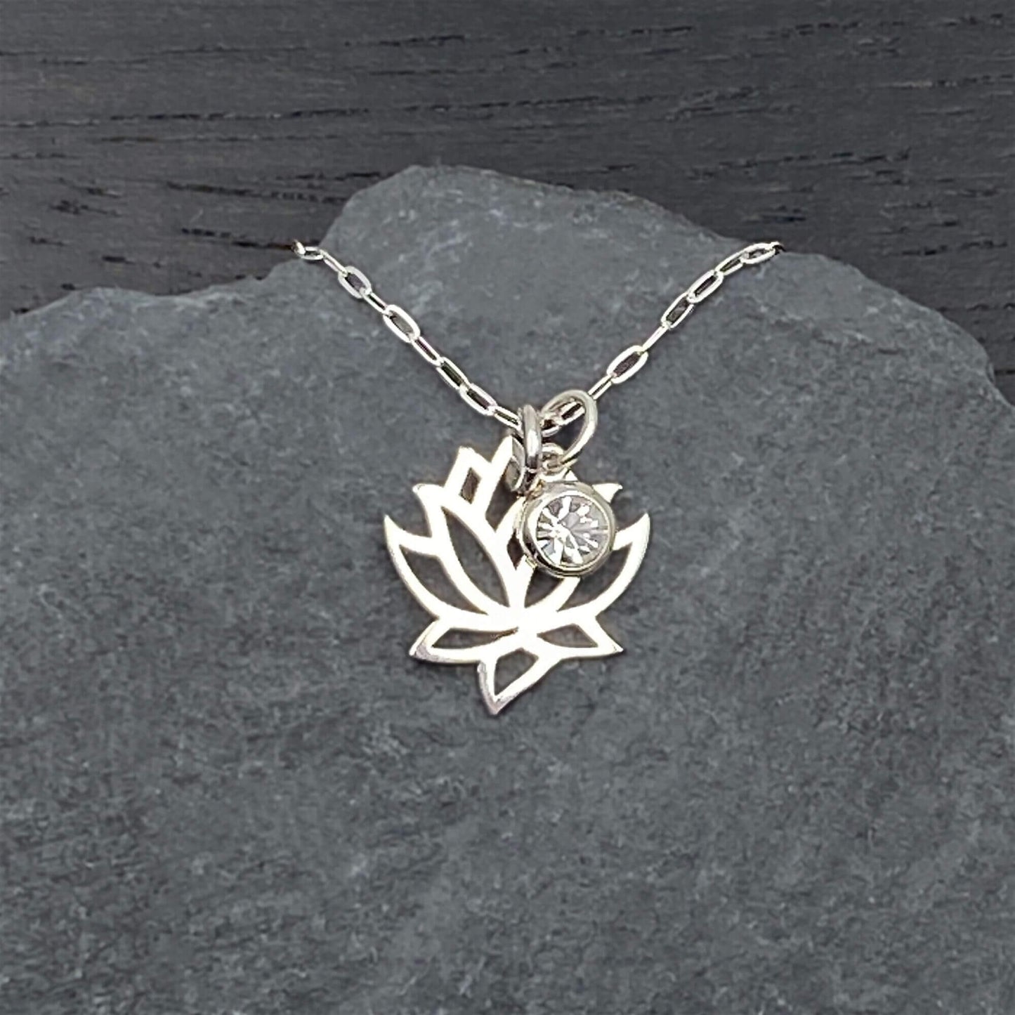 Openwork lotus flower and accent crystal dangle charm on a sterling silver chain.