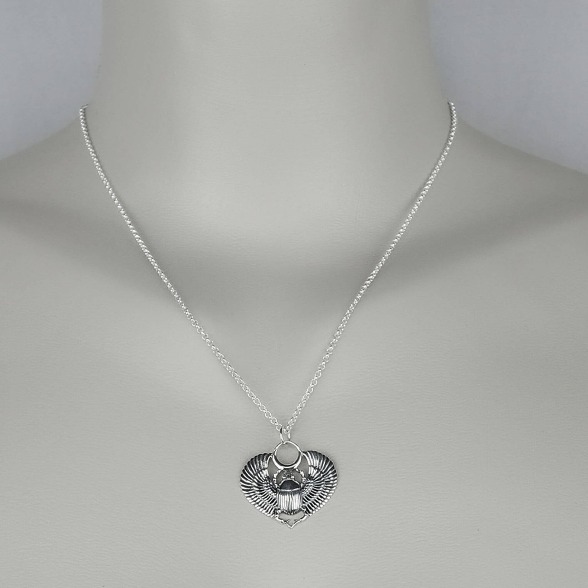A woman wearing a sterling silver chain necklace with a trendy egypt scarab   pendant.