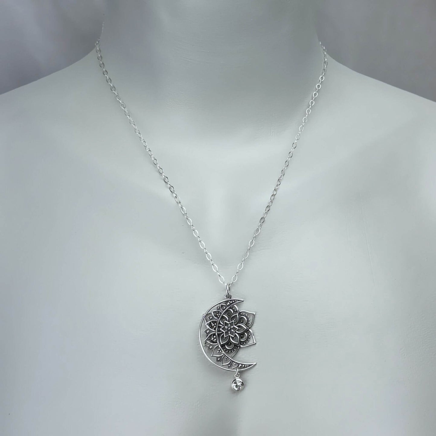Female model wearing a sun, moon and star pendant necklace with a sterling silver chain.