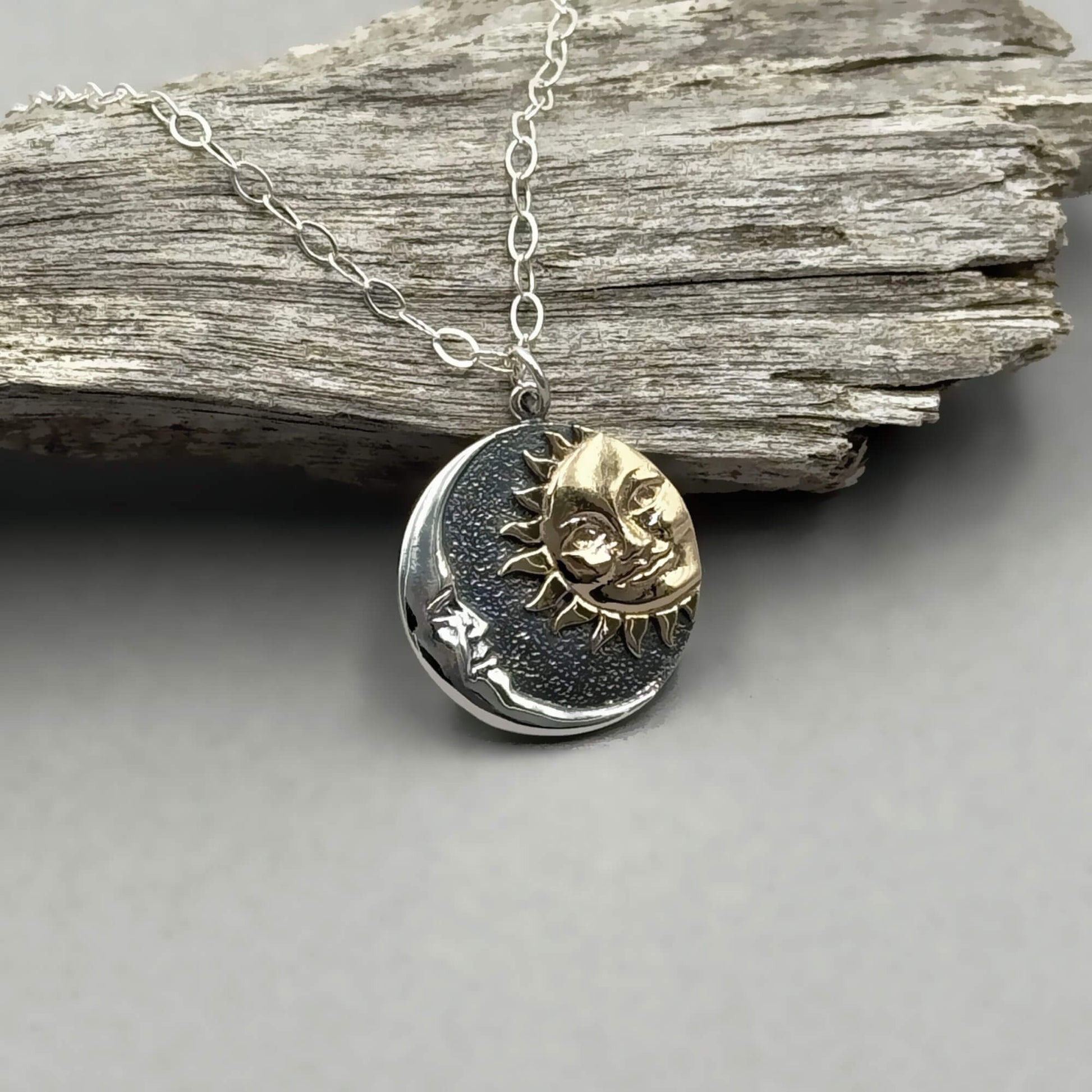 Round shaped silver mixed metal sun and moon pendant on a sterling silver chain.