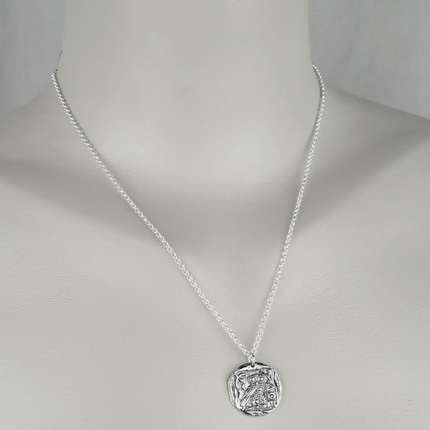 Female wearing a necklace with sterling silver chain and Athena replica coin pendant.