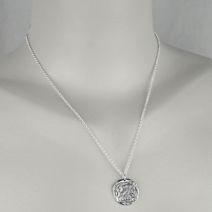 Female wearing a necklace with sterling silver chain and Athena replica coin pendant.