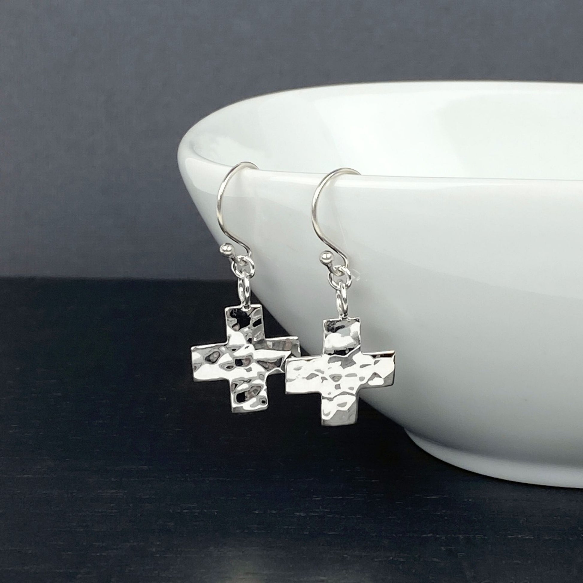 Sterling silver modern earrings on silver Bali hook ear wires with a cross design.