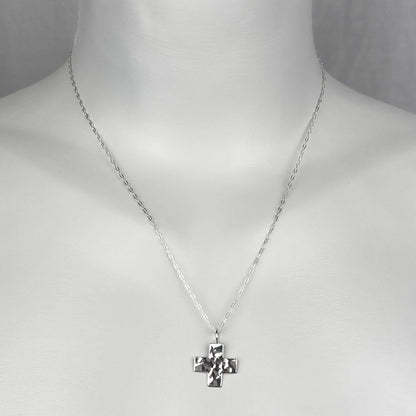 A woman model wearing a sterling silver chain necklace with a trendy chunky cross small charm.