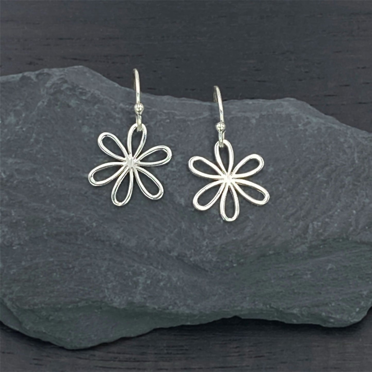 Charming sterling silver earrings on silver hook ear wires with a modern daisy design.