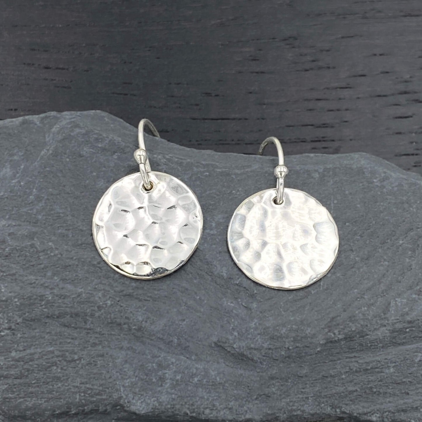 Detailed view of silver minimalist earrings with a beautiful hammered disc design.