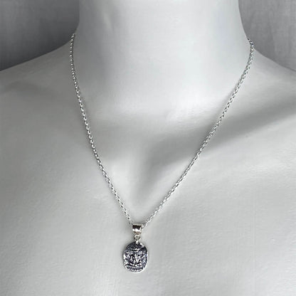 A woman wearing a sterling silver chain necklace with a hindu Ganesh god  pendant charm on a silver chain.