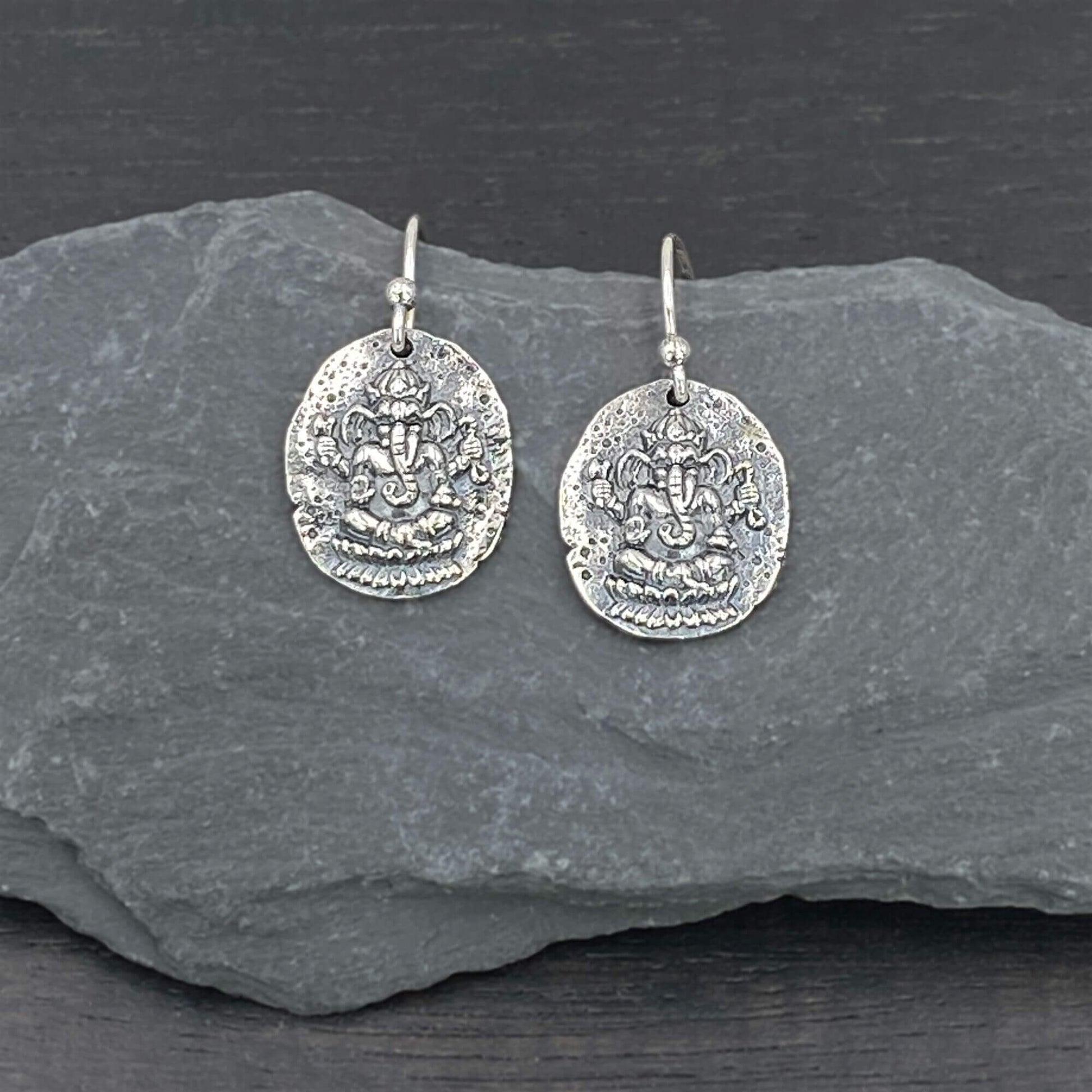 Detailed view of silver circular earrings with a Hindu spiritually-inspired Ganesh design.