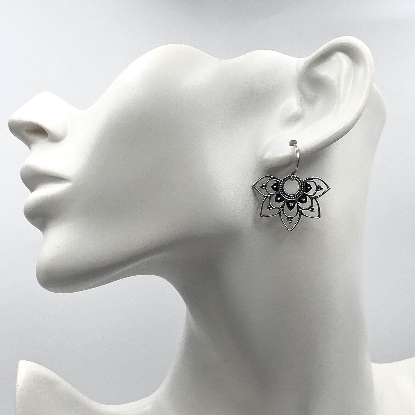 Model of a woman wearing silver boho-chic half mandala dangle earrings.