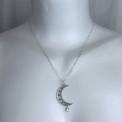 Model of a female wearing our Moon and Star necklace, featuring a large moon pendant on a silver cable chain.