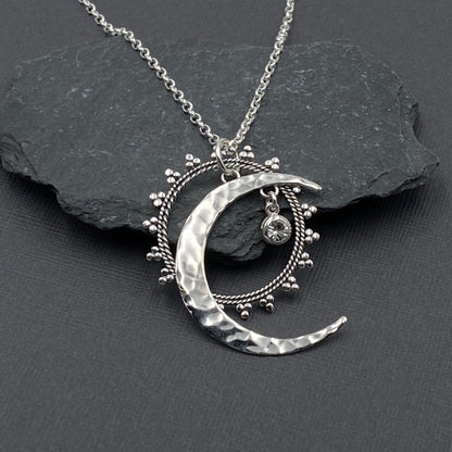 Detailed view of a crescent moon, boho mandala and crystal star pendant in sterling silver. 