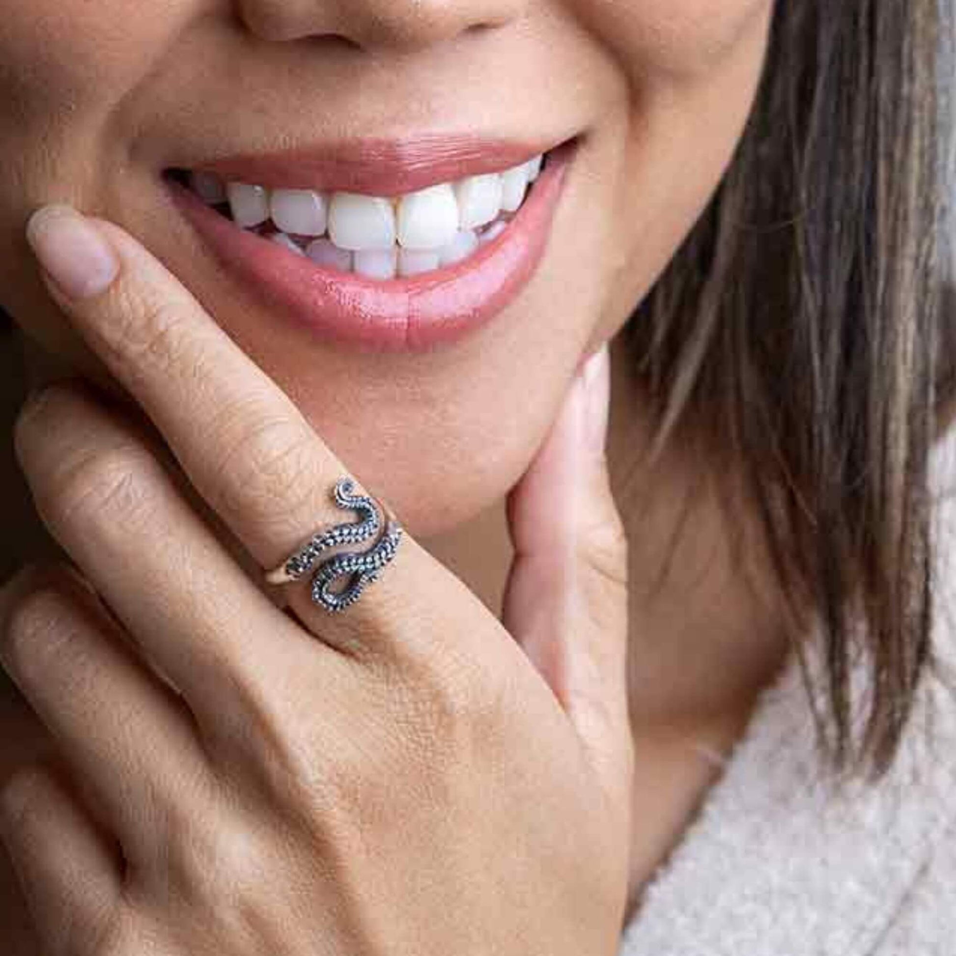 Womans hand model showing how our silver octopus ring two tentacles wrap elegantly around the front of the finger meeting at the front. 