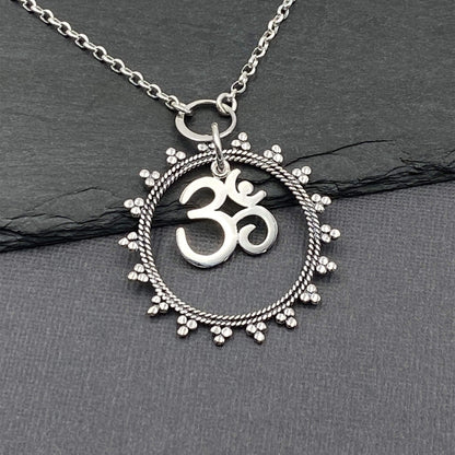 Openwork silver mandala ring with a ohm symbol charm pendant on a silver chain. Yoga jewelry for women. 