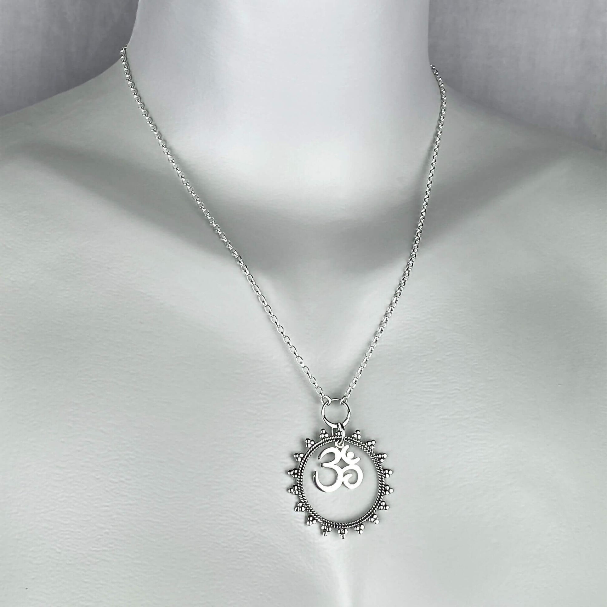 A woman wearing a sterling silver chain necklace with Om symbol and Mandala pendant.