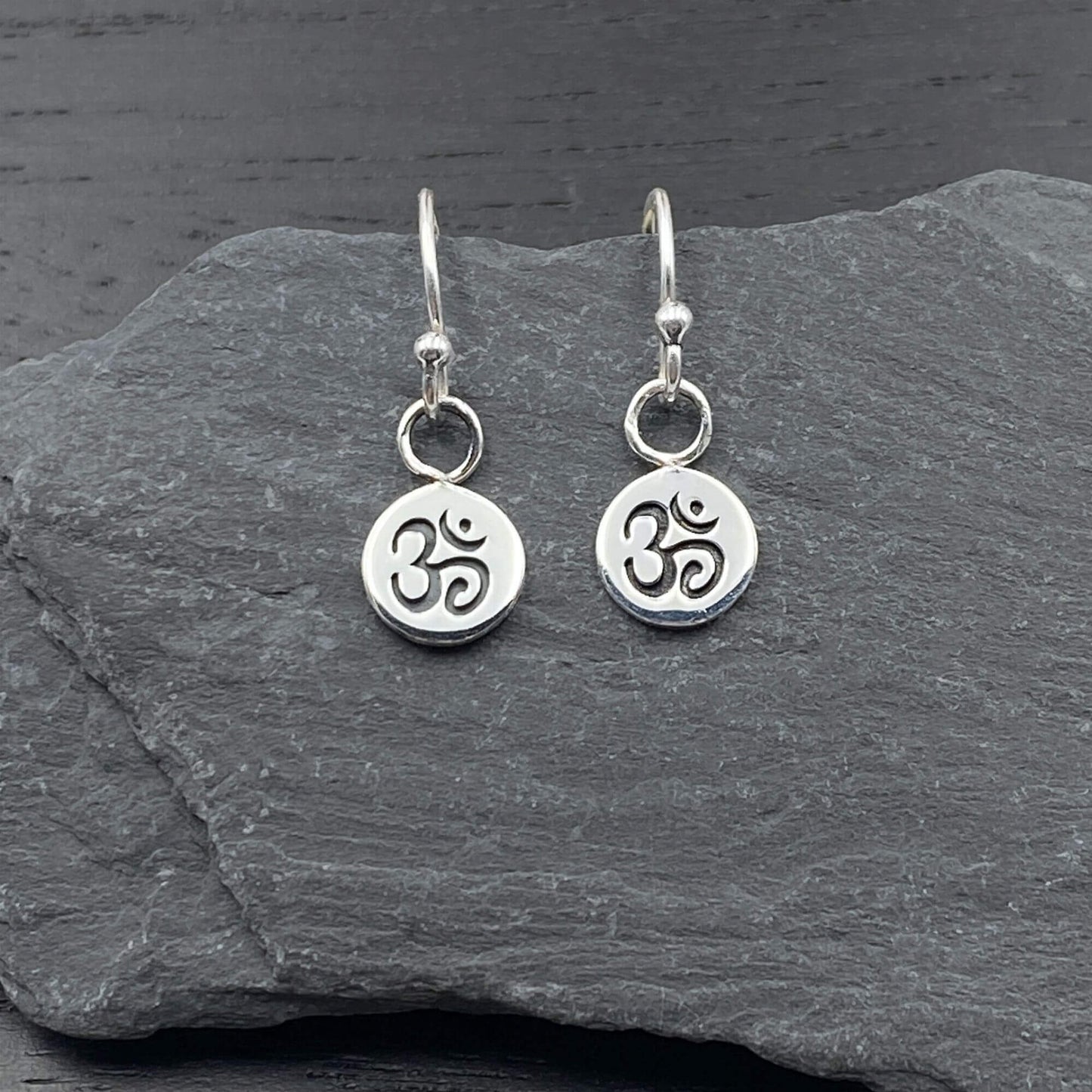 Sterling silver circular earrings on silver hook ear wires with a spiritual Om symbol design.