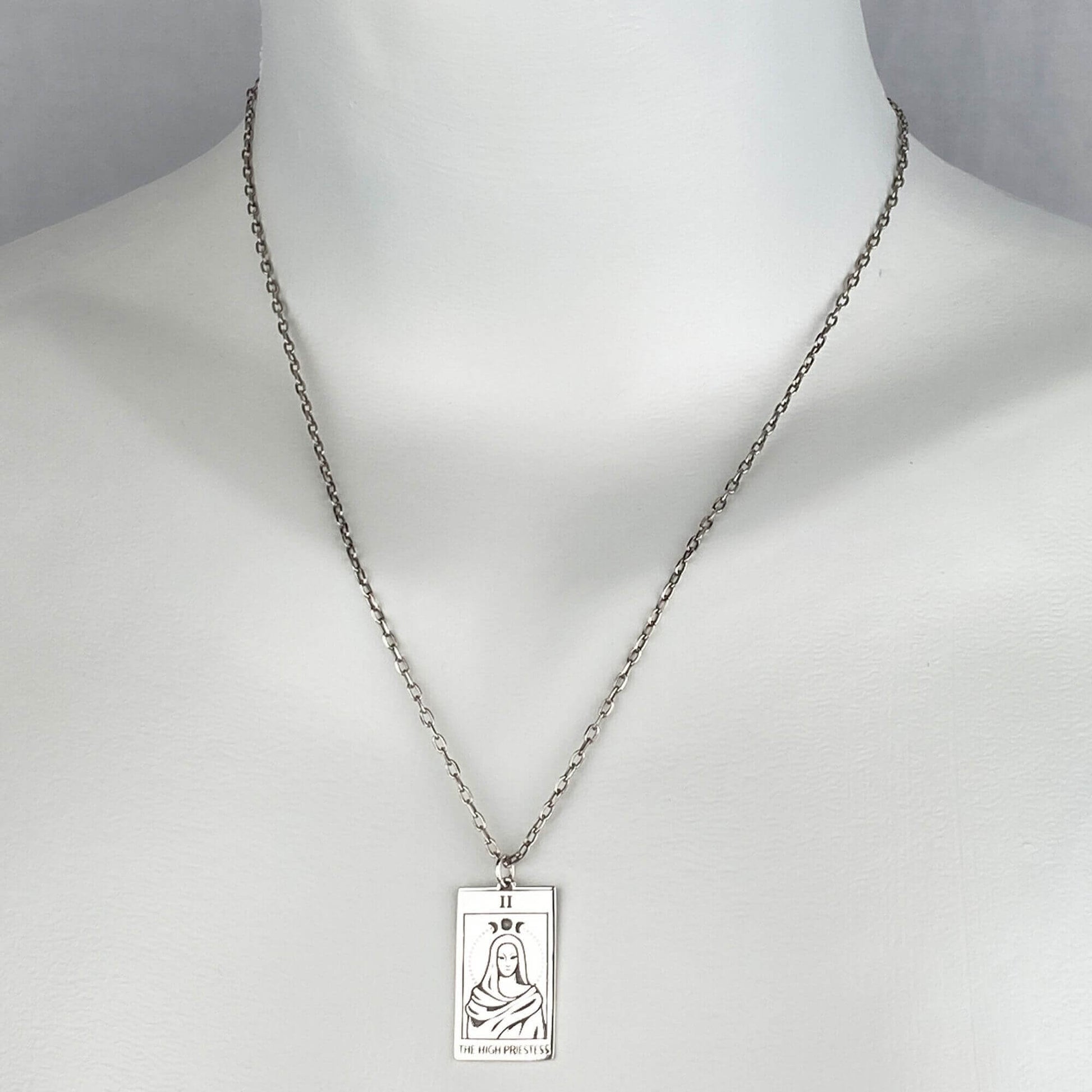 A woman wearing a sterling silver chain necklace with a trendy tarot card  goddess pendant.