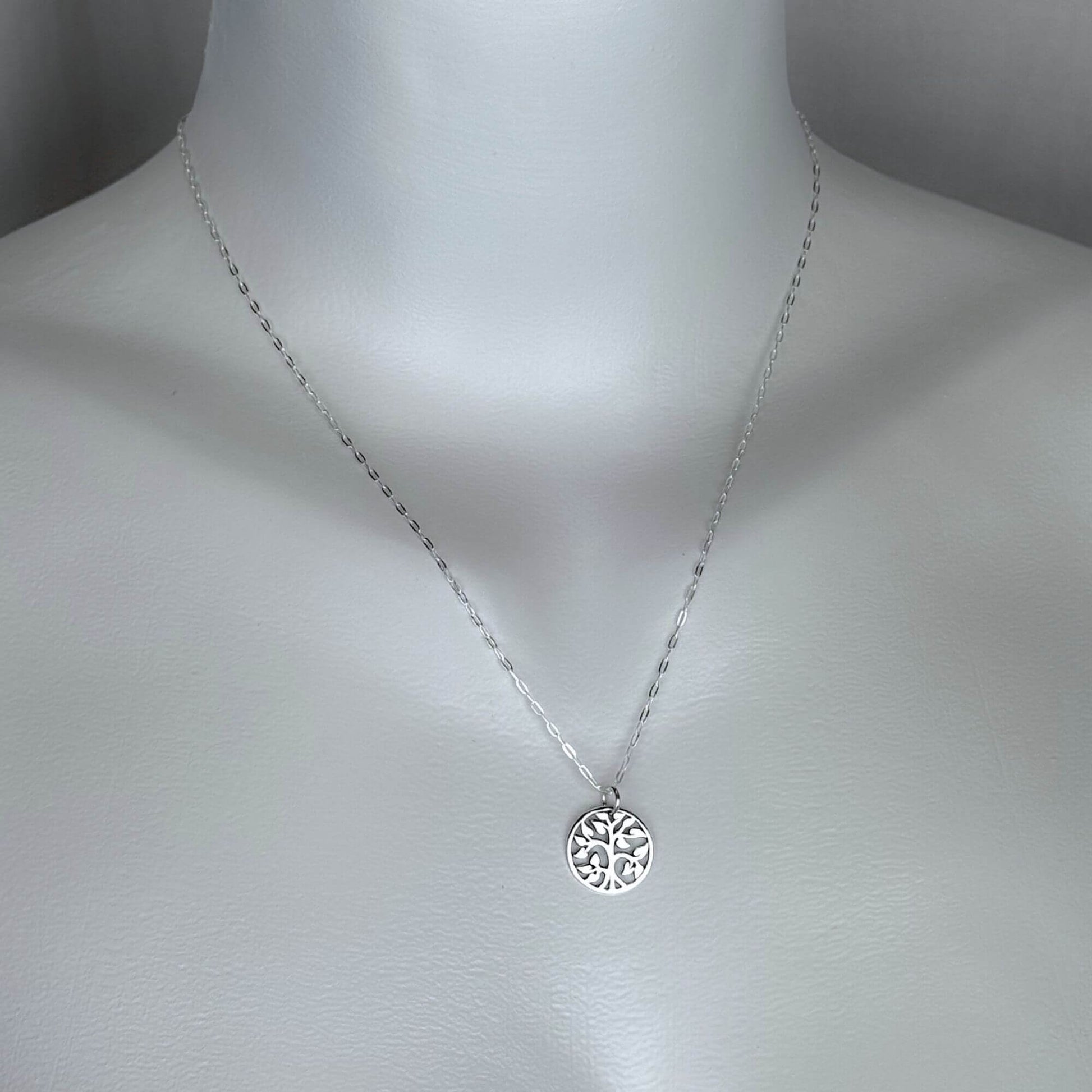 A woman wearing a 925 solid sterling silver necklace with a tiny tree charm pendant with a 925 solid sterling silver chain. Our silver jewelry collection is intended for females.