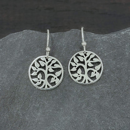 Close up view of 925 solid sterling silver earrings dangling from hook earwires with small circular Tree of Life charms with an openwork cut out design.  The tree charms are 5/8" tall and dangle freely.  A perfect jewelry gift for nature lovers.