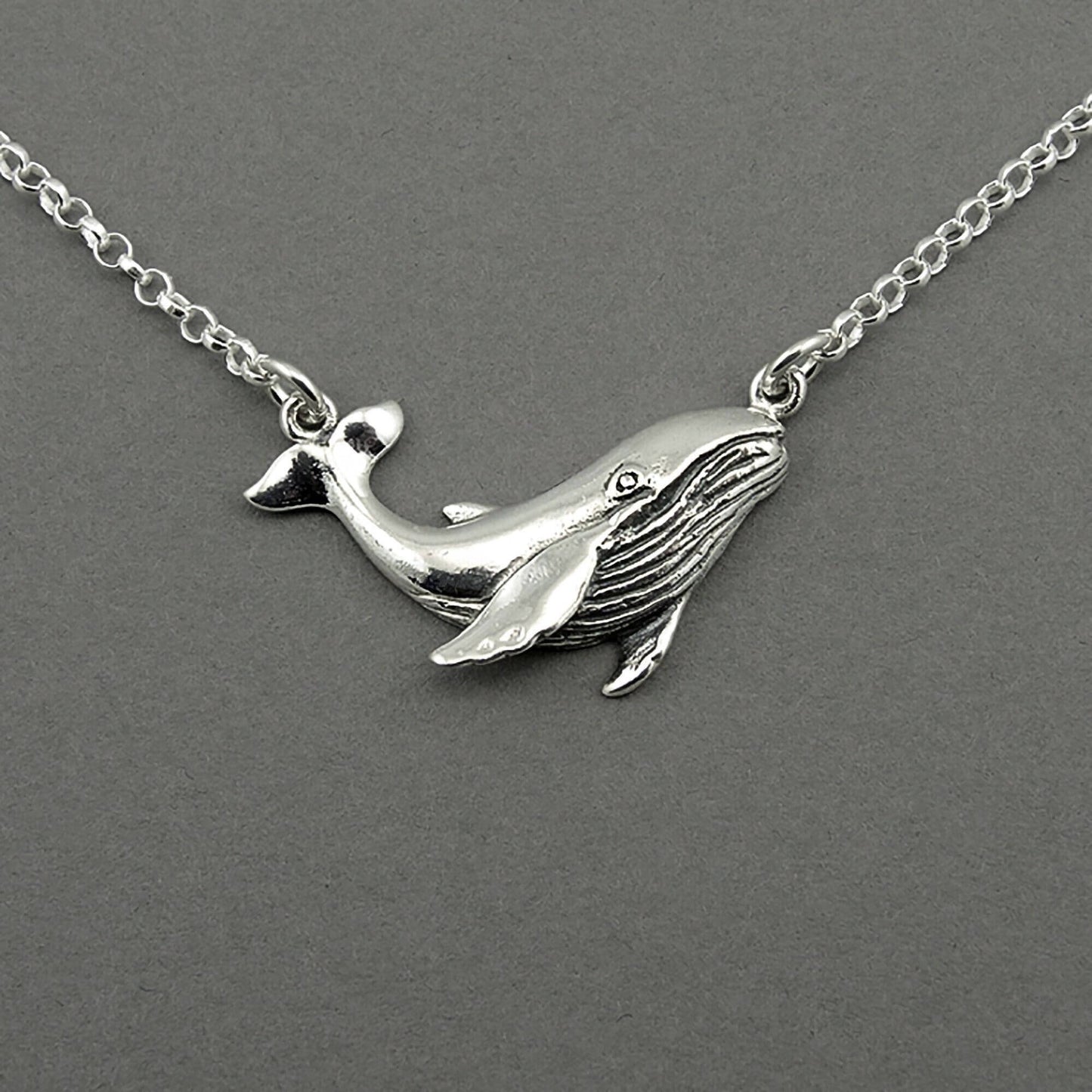 Sterling silver humpback whale pendant floating on the silver chain.  The whale is detailed.